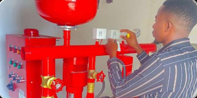 Technician working on a red fire pump and control panel